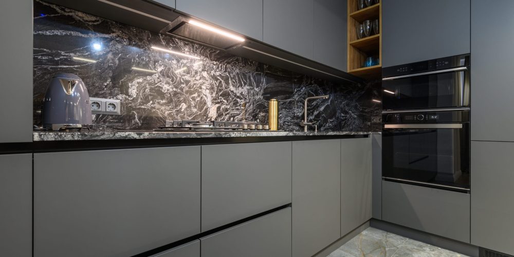 Corner view closeup to grey luxury kitchen Corner view closeup to grey luxury kitchen in studio apartment interior
